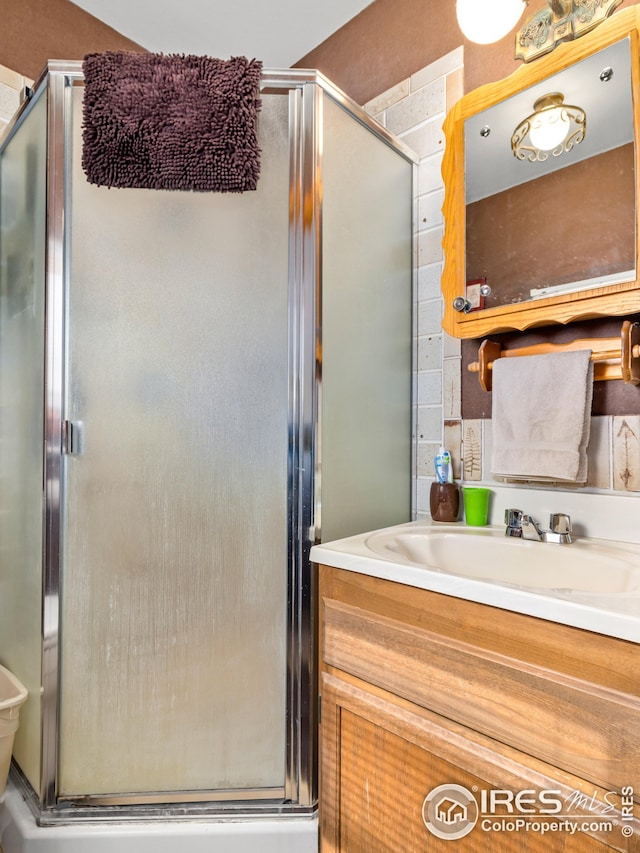 bathroom featuring a shower stall and vanity