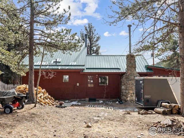 view of side of home with a chimney and metal roof