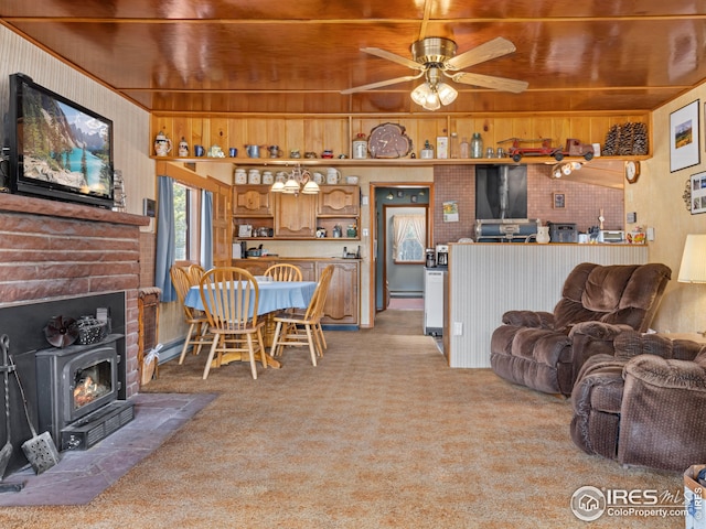 living room featuring wooden walls, light colored carpet, and a ceiling fan