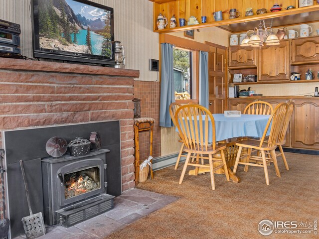 dining area featuring a wood stove and carpet