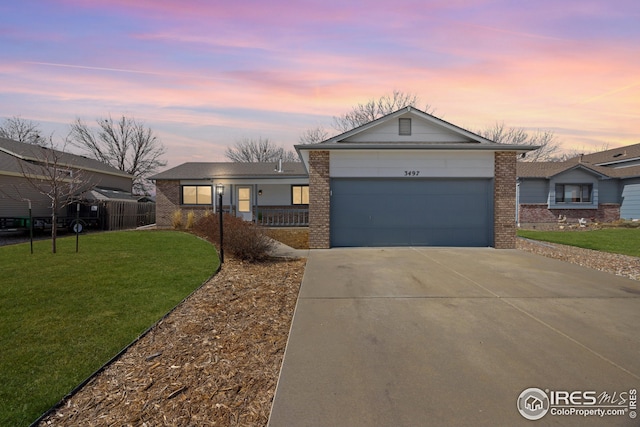 ranch-style house featuring brick siding, a lawn, driveway, and an attached garage