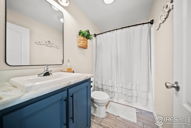 bathroom featuring vanity, wood tiled floor, shower / bath combination with curtain, vaulted ceiling, and toilet