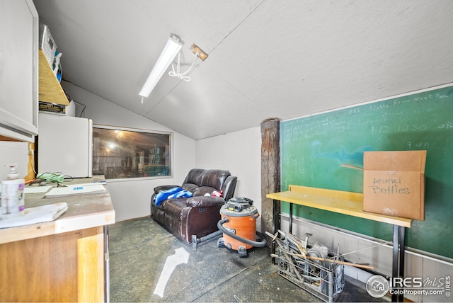 interior space with vaulted ceiling and concrete floors