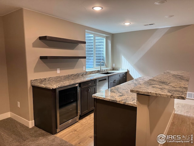 kitchen with visible vents, a sink, light stone countertops, beverage cooler, and open shelves