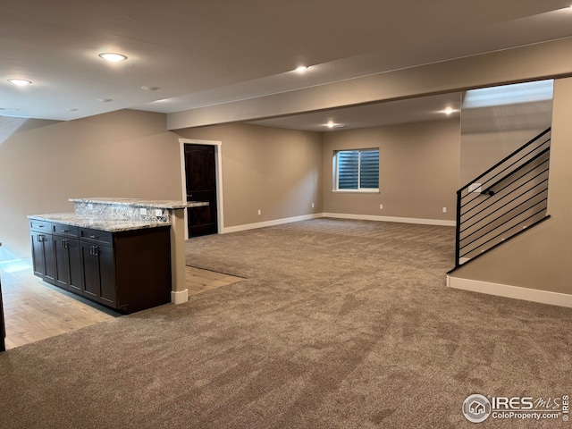 interior space with stairway, baseboards, and light colored carpet