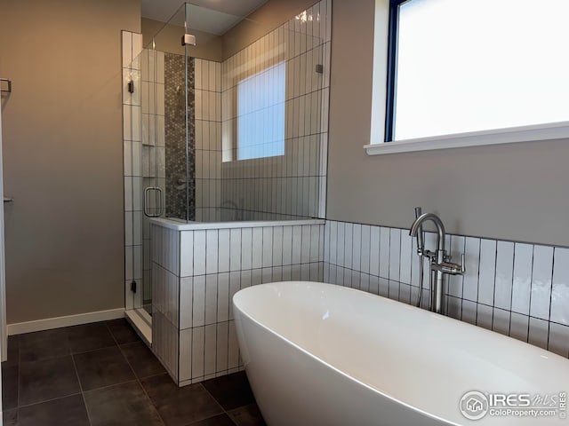 full bath with a soaking tub, a stall shower, and tile patterned flooring