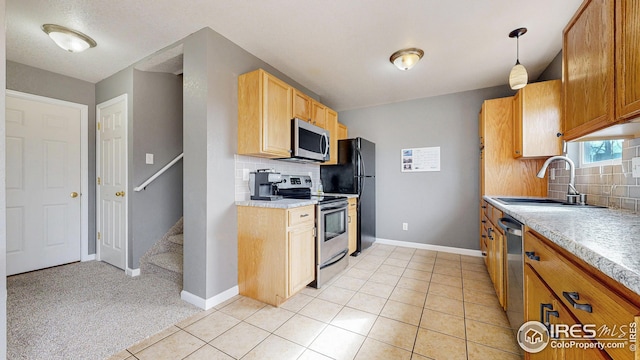 kitchen featuring a sink, appliances with stainless steel finishes, light tile patterned flooring, and light countertops