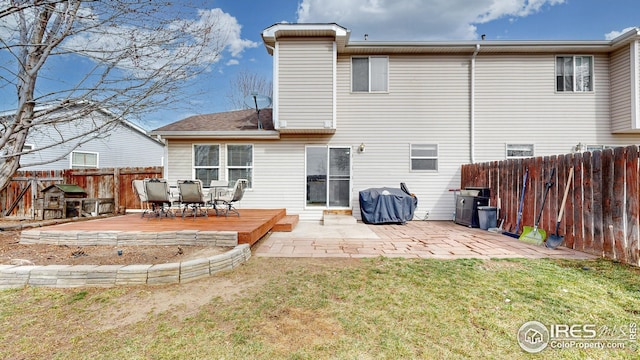 rear view of property with a wooden deck, a lawn, a fenced backyard, and a patio area