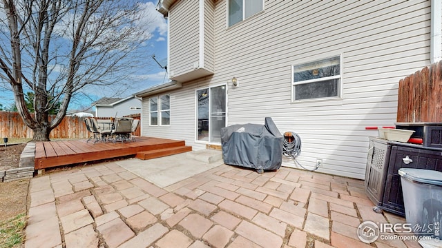 view of patio featuring grilling area, outdoor dining space, fence private yard, and a deck