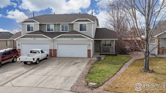 view of front of property featuring brick siding, a front lawn, roof with shingles, a garage, and driveway