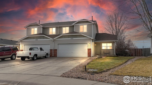 traditional-style home with driveway, fence, an attached garage, a shingled roof, and brick siding