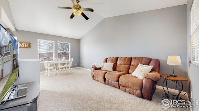 living room featuring carpet flooring, ceiling fan, baseboards, and vaulted ceiling