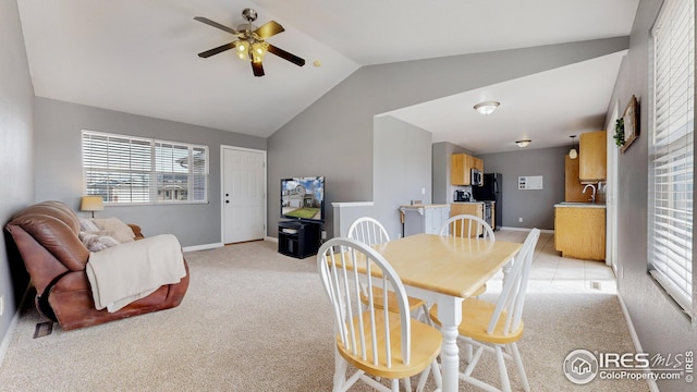 dining space with baseboards, lofted ceiling, light carpet, and a ceiling fan