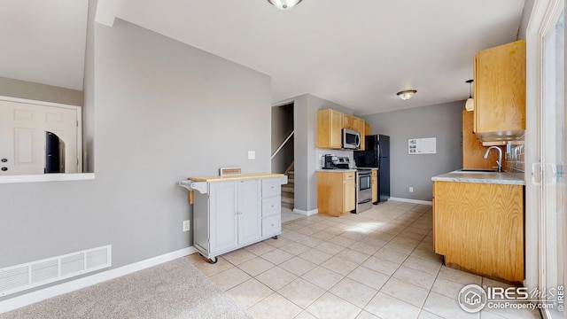 kitchen with visible vents, a sink, appliances with stainless steel finishes, light countertops, and light tile patterned floors