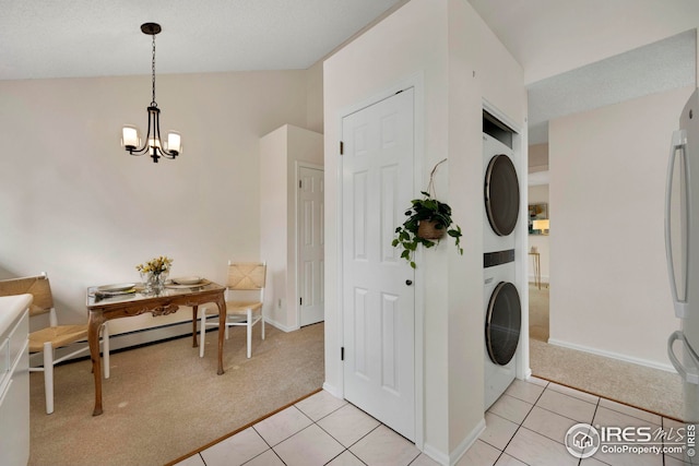 laundry area featuring light tile patterned flooring, laundry area, light colored carpet, and stacked washer and clothes dryer