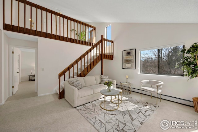 carpeted living area featuring a baseboard heating unit, high vaulted ceiling, and stairs