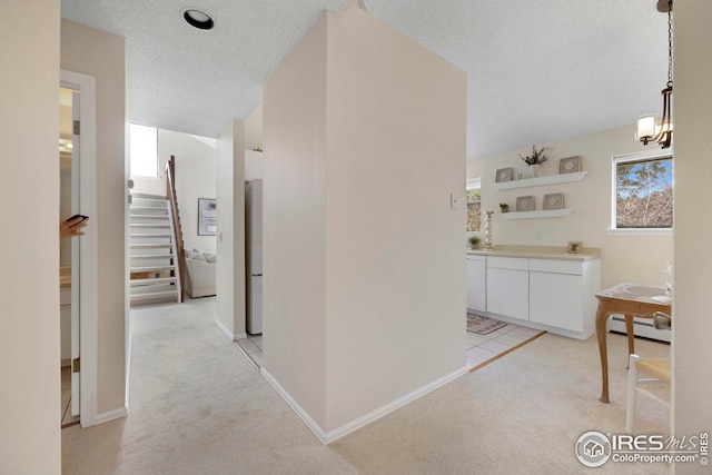 hallway featuring stairway, light colored carpet, a baseboard radiator, and a textured ceiling