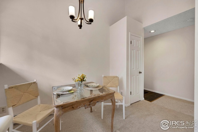 dining room featuring a notable chandelier, carpet flooring, and baseboards