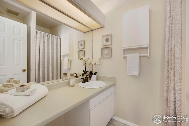 bathroom with visible vents, baseboards, vanity, and tile patterned flooring