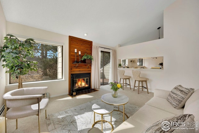 living area with lofted ceiling, carpet flooring, baseboards, and a fireplace with flush hearth