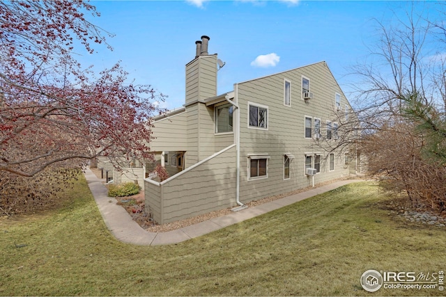 back of property featuring a lawn and a chimney