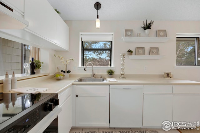 kitchen with electric range, white dishwasher, a sink, a textured ceiling, and white cabinetry