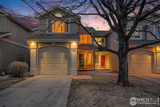 traditional-style house with stucco siding and concrete driveway