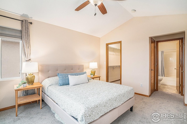 carpeted bedroom featuring baseboards, ceiling fan, vaulted ceiling, a closet, and a walk in closet