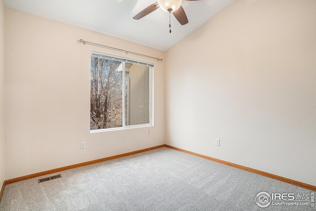 carpeted spare room featuring visible vents, baseboards, ceiling fan, and vaulted ceiling