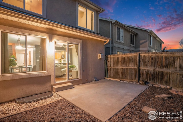 exterior space with a patio area, fence, and stucco siding