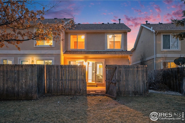 back of property featuring stucco siding and fence