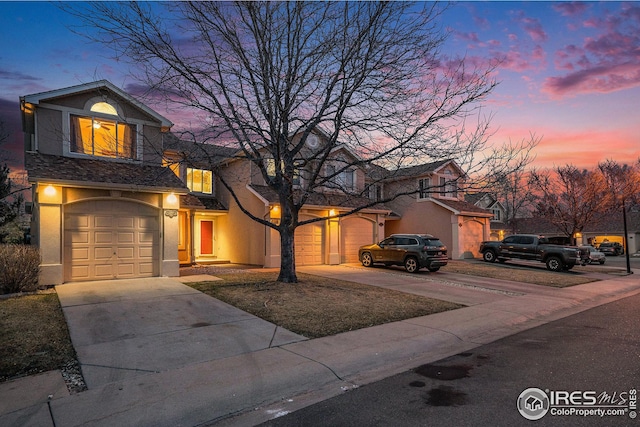 view of front of home with stucco siding, concrete driveway, and a garage