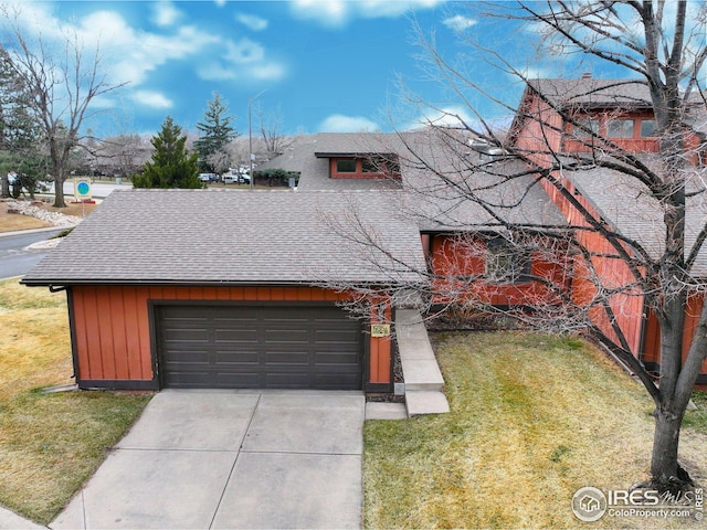 view of front of house featuring a front lawn, an attached garage, driveway, and a shingled roof