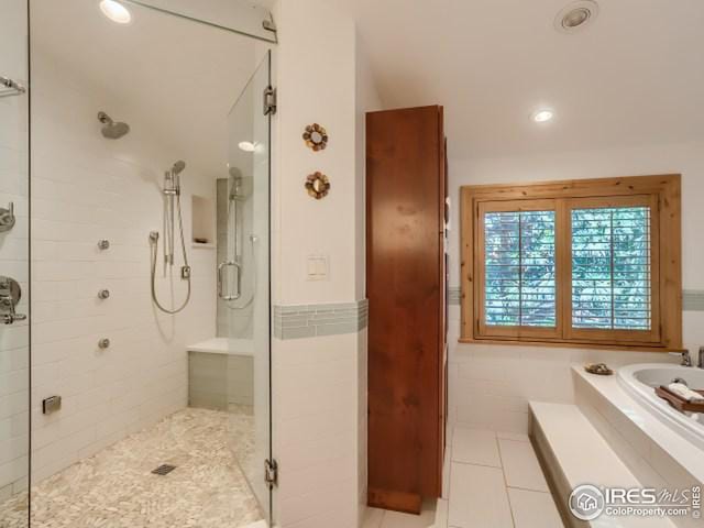 bathroom featuring a garden tub, a stall shower, and tile patterned flooring