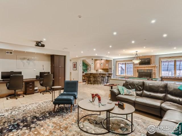 living room featuring light tile patterned floors, visible vents, recessed lighting, and a fireplace