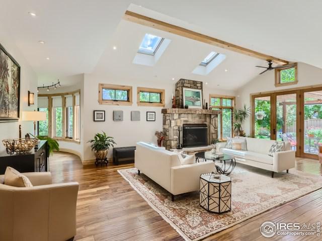 living room featuring wood finished floors, high vaulted ceiling, recessed lighting, a fireplace, and beamed ceiling