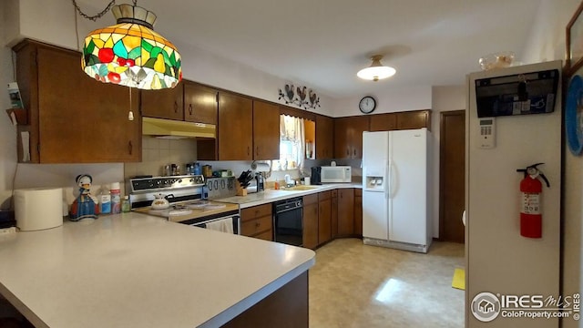 kitchen featuring under cabinet range hood, white appliances, light countertops, and a peninsula