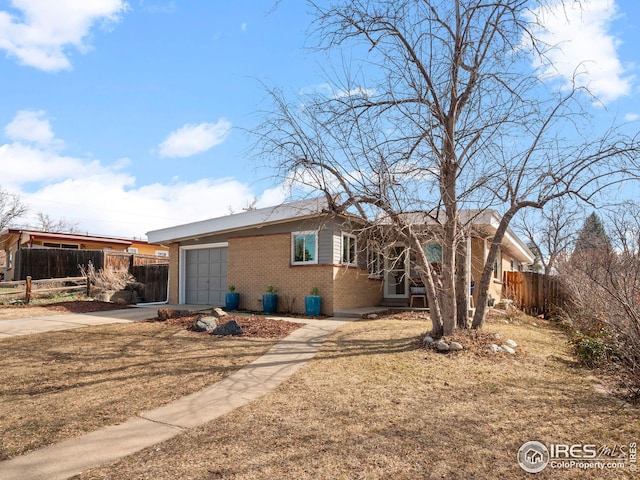 ranch-style house featuring concrete driveway, an attached garage, fence, and brick siding