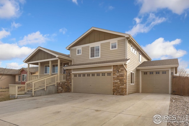 view of front facade featuring concrete driveway, a garage, board and batten siding, and stone siding