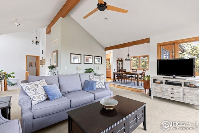 living area with a stone fireplace, beamed ceiling, and high vaulted ceiling