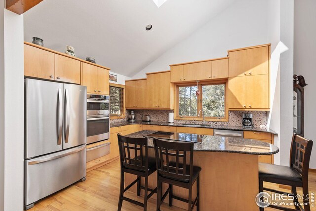 dining room with plenty of natural light, light wood-style flooring, and an inviting chandelier