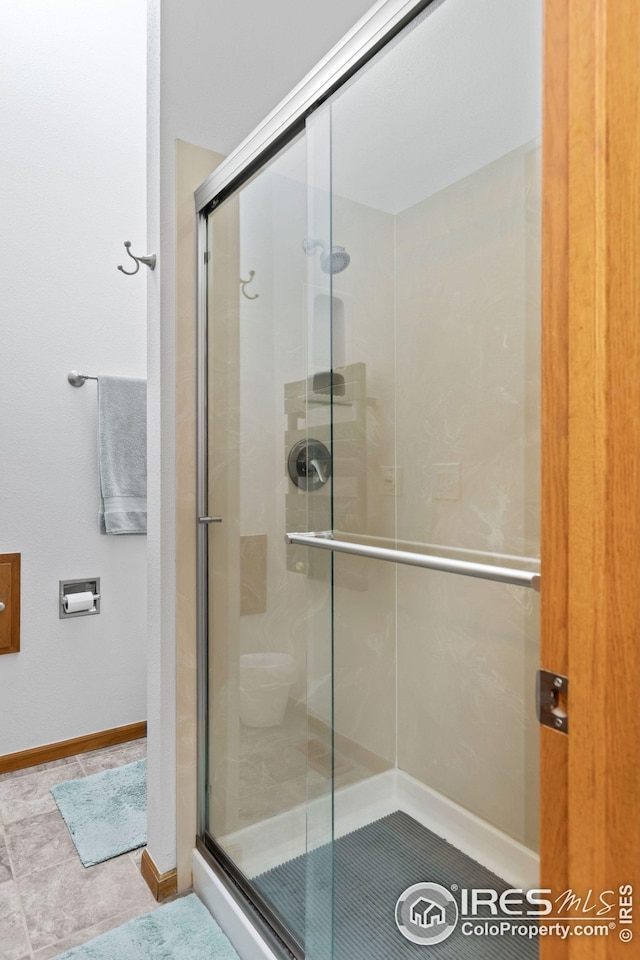 bathroom featuring baseboards and a stall shower