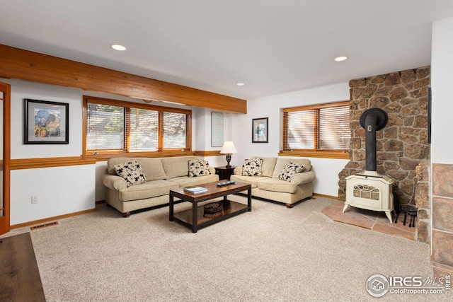 carpeted living area featuring recessed lighting, visible vents, plenty of natural light, and a wood stove