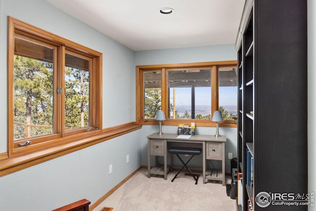 office area with light carpet, a healthy amount of sunlight, and baseboards