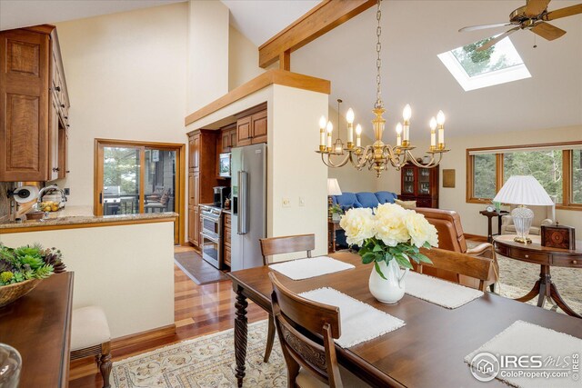 dining area featuring high vaulted ceiling, beamed ceiling, a skylight, and light wood-style floors