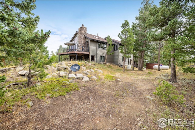 rear view of house with a wooden deck and a chimney