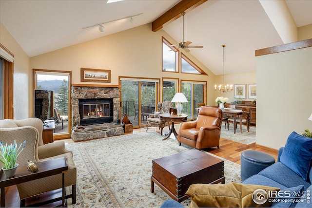 living area with beam ceiling, high vaulted ceiling, ceiling fan with notable chandelier, wood finished floors, and a fireplace