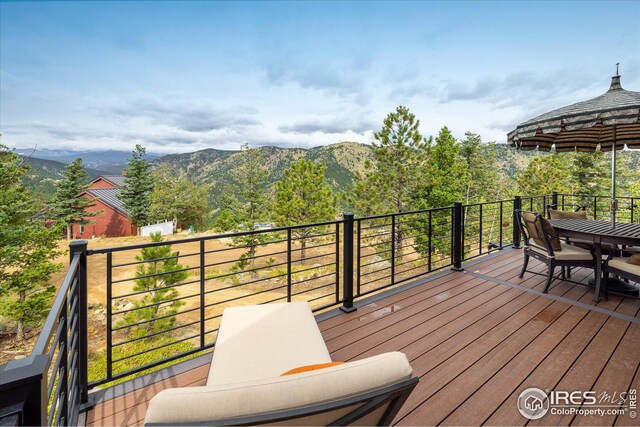 deck with outdoor dining space and a mountain view