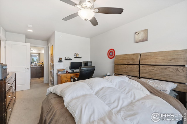 bedroom with ceiling fan, ensuite bathroom, and light carpet