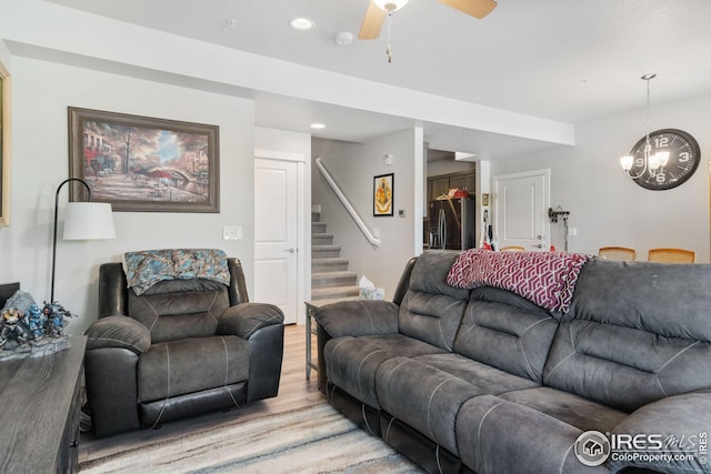 living area with stairs, recessed lighting, ceiling fan with notable chandelier, and light wood finished floors